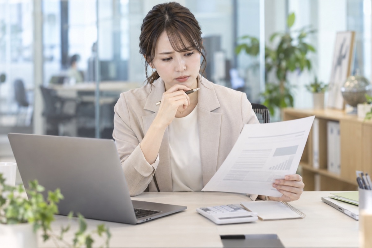 見積書を前に費用を確認する女性マーケティング担当者